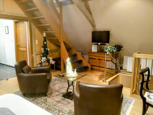 a living room with a couch and a tv at Maison Rebleuthof Sauna & Fitness in Riquewihr