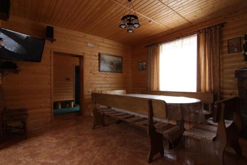 a living room with a bench and a television in a log cabin at Proskurov Holiday Home in Bukovel