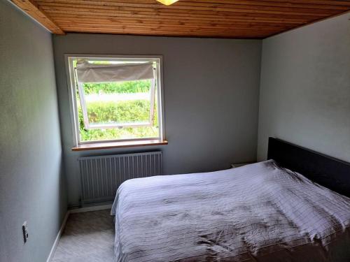 1 dormitorio con cama y ventana en Cozy villa, en Aarhus