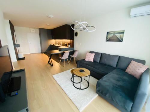 un soggiorno con divano e tavolo di New apartment with free parking near the airport a Prievoz