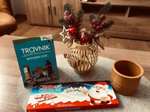 Een doos kerstgranen en een boek op tafel. bij Travnik Nostalgia Apartment in Travnik