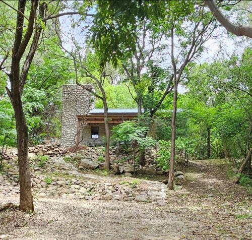 uma casa de pedra no meio de uma floresta em Las Casitas de Piedra I em Villa General Belgrano