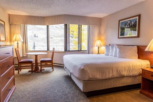 une chambre d'hôtel avec un lit et une table avec des chaises dans l'établissement Studio Perfect Location 320 with Pool and Hot Tub, à Crested Butte