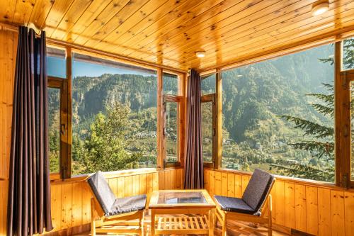 a room with two chairs and a table with a view at Timberwolves in Manāli