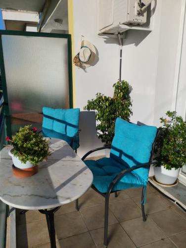 un patio con 2 sillas, una mesa y algunas plantas en Sweet Home, en Egio