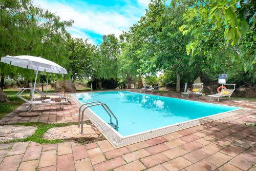 uma grande piscina com guarda-sol e cadeiras em Agri Resort San Giuliano em Santa Maria la Palma