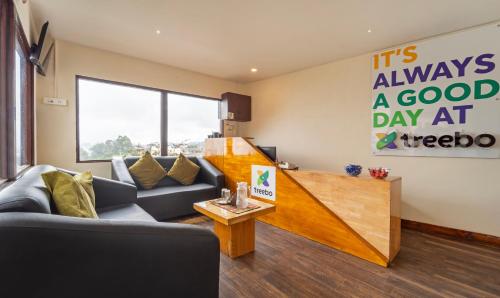 a living room with a couch and a clock on the wall at Treebo Tranquil Heights in Kodaikānāl