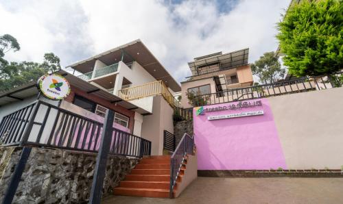 a house with a pink and purple wall at Treebo Tranquil Heights in Kodaikānāl