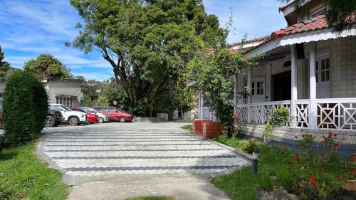 a parking lot next to a house with parked cars at Bruton resorts in Kodaikānāl