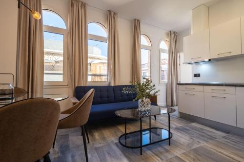 a living room with a blue couch and a table at William Martin Apartments in Huelva