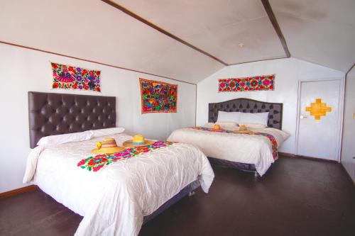 a bedroom with two beds with flowers on them at Mojsa titicaca lodge in Puno