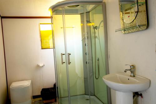 a bathroom with a glass shower and a sink at Mojsa titicaca lodge in Puno