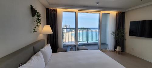 una camera con letto e vista su un balcone di SurfResort INN-The City YangYang a Yangyang