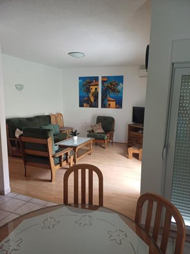 uma sala de estar com cadeiras e uma mesa em Apartment Sano em Podstrana