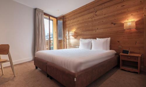 um quarto com uma cama e uma parede de madeira em Hôtel Lyret em Chamonix-Mont-Blanc