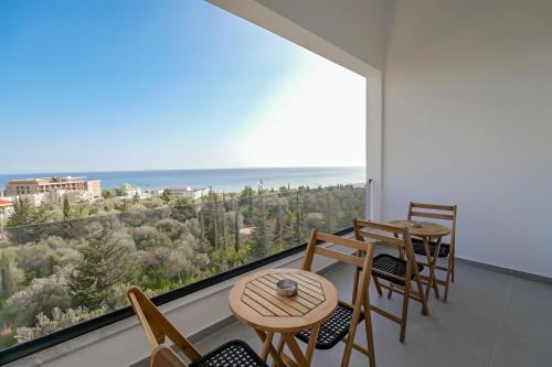 een balkon met tafels en stoelen en uitzicht op de oceaan bij Domi Beach Valley in Dhërmi