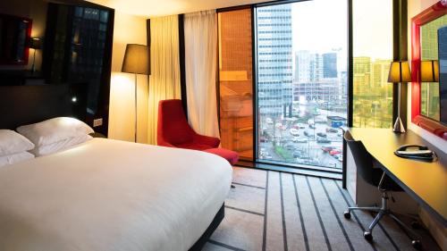 a hotel room with a bed and a desk and a window at Crowne Plaza Manchester City Centre, an IHG Hotel in Manchester