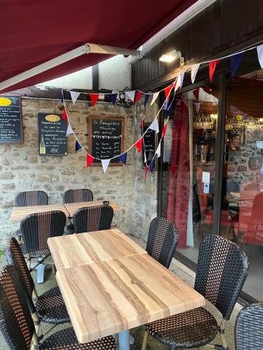 uma mesa de madeira e cadeiras em frente a um restaurante em Hotel Duchesse Anne em Dinan