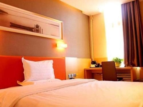 ein Hotelzimmer mit einem Bett und einem Schreibtisch in der Unterkunft IU Hotel Tianjin Binjiang Walk Street Branch in Tianjin