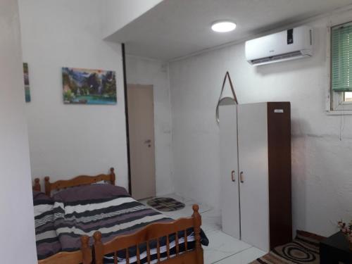 een kleine kamer met een bed en een koelkast bij Rooms Struga in Struga