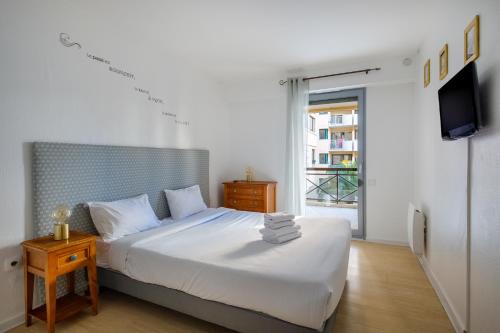 - une chambre avec un lit blanc et une télévision dans l'établissement Residhotel Villa Maupassant, à Cannes