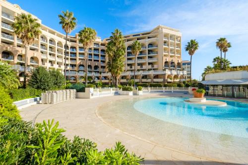 un hôtel avec une piscine en face d'un bâtiment dans l'établissement Residhotel Villa Maupassant, à Cannes