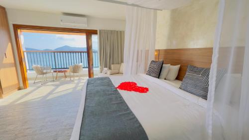 um quarto com uma cama e vista para o oceano em Catalina Hotel em Ubatuba