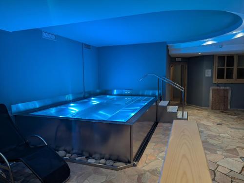 einen Whirlpool in einem Zimmer mit blauer Beleuchtung in der Unterkunft Hotel Garni Arnica ***S in Madonna di Campiglio