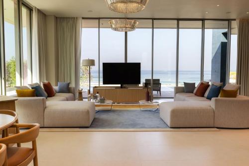 ein Wohnzimmer mit Sofas und einem Flachbild-TV in der Unterkunft Ajman Hotel by Blazon Hotels in Ajman 