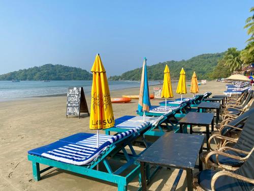 szereg leżaków i parasoli na plaży w obiekcie Chill Out Jasmine Restaurant Bar Rooms w mieście Palolem