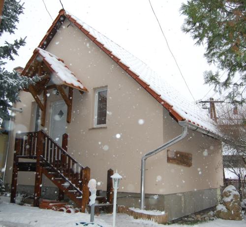 una casa coperta di neve di fronte di Maya Guesthouse a Eger