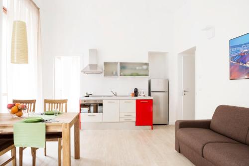 een keuken en een woonkamer met een tafel en een bank bij TorinoToStay Apartments in Turijn