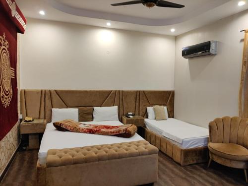 Habitación de hotel con 2 camas y sofá en Hotel De Smart Multan, en Multán