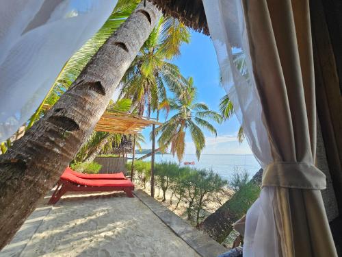 Cette chambre offre une vue sur la plage et l'océan. dans l'établissement KINTANA LODGE, sur l'île aux Nattes