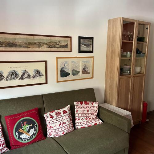 a living room with a couch with pillows on it at appartamento Cervinia fronte Funivie in Breuil-Cervinia