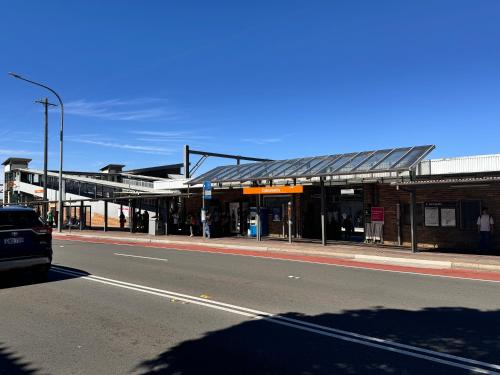 een bushalte in een stadsstraat met een weg bij Alison's central apartment in Cabramatta