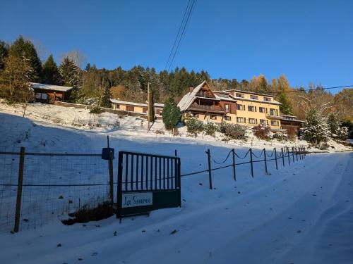 a fence in the snow in front of a house at La source in Sondernach