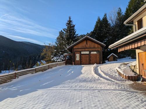 a snow covered driveway to a cabin in the mountains at La source in Sondernach