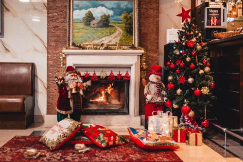 un salon avec un arbre de Noël et une cheminée dans l'établissement Business Hotel Plovdiv, à Plovdiv