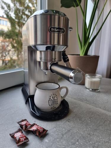 Apartament Coffee Time في تارنوف: وجود آلة صنع القهوة على طاولة مع كوب