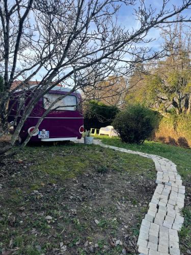 een paarse bus geparkeerd naast een bakstenen weg bij Salève Glamping in Archamps