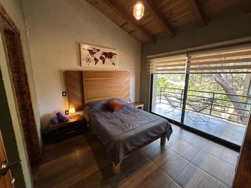 1 dormitorio con cama y ventana grande en Cabaña de Lujo LA HERRADURA, Mazamitla, en Mazamitla