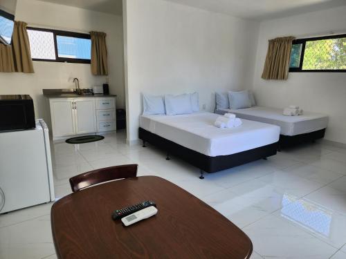 een kamer met 2 bedden, een tafel en een keuken bij Fugalei Motel in Apia