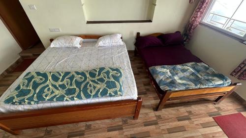 two beds sitting in a room with at AG Cottage Vattakanal in Kodaikānāl