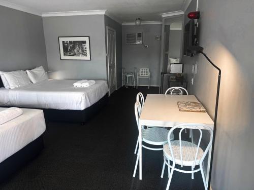 um quarto de hotel com duas camas e uma mesa e cadeiras em Old Maitland Inn em Maitland