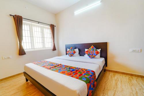 a bedroom with a large bed in a room at FabHotel Saro Sri Residency in Coimbatore