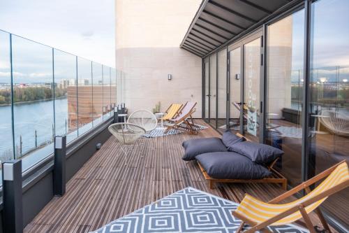 een balkon met stoelen en uitzicht op een rivier bij Résidence Kley Clichy in Clichy