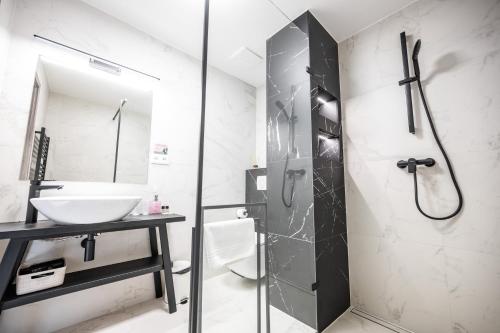 een badkamer met een douche, een wastafel en een douche bij Hotel Litovel in Luhačovice