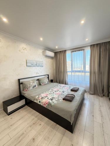 um quarto com uma cama grande e uma janela grande em Vip Luxury APARTMENT em Burgas