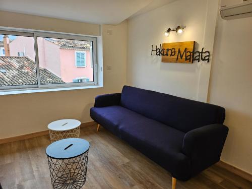 a living room with a blue couch and two stools at Sur les toits in Draguignan